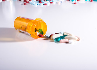 Pill bottle spilling a variety of medications