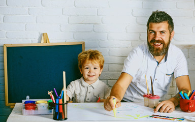 Art for children. Bearded adult father teaches to draw little son in studio. Boy and man draw picture. Creative education and art, development in kindergarten. Childhood with parents talented teacher