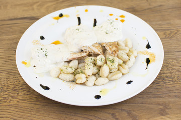 Nice stuffed chicken breast with gnocchi. White cream topping with the touch of green seasoning. Beautifully served plate at the restaurant.