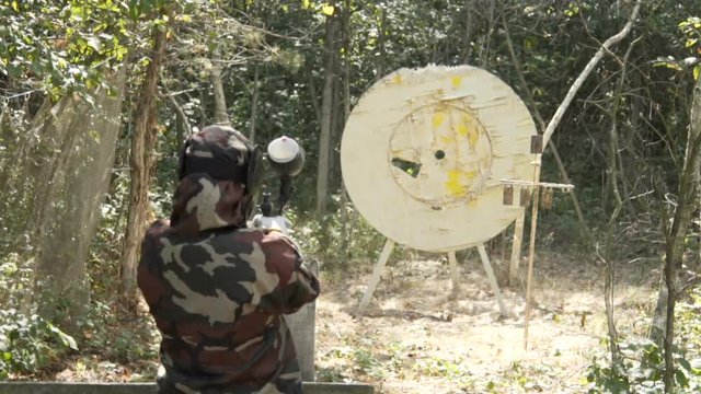 People play paintball in the woods. 60 fps