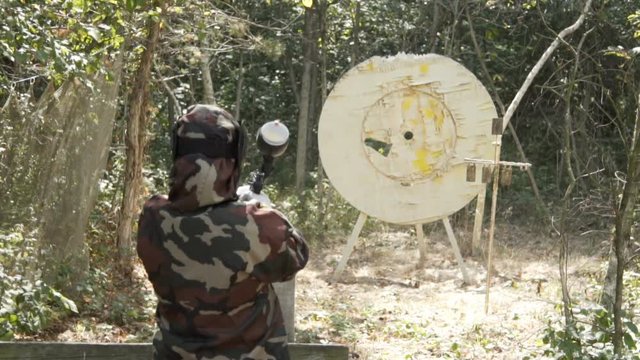 People play paintball in the woods