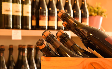 Wine bottles on wooden shelf in wine store