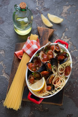 Spaghetti with seafood on a brown stone background, high angle view, studio shot