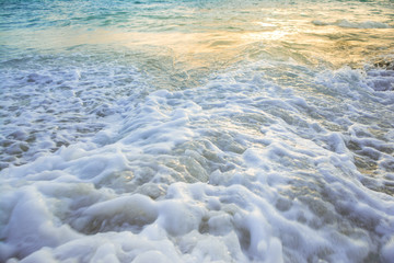 Splash soft waves hit the shore with sunlight