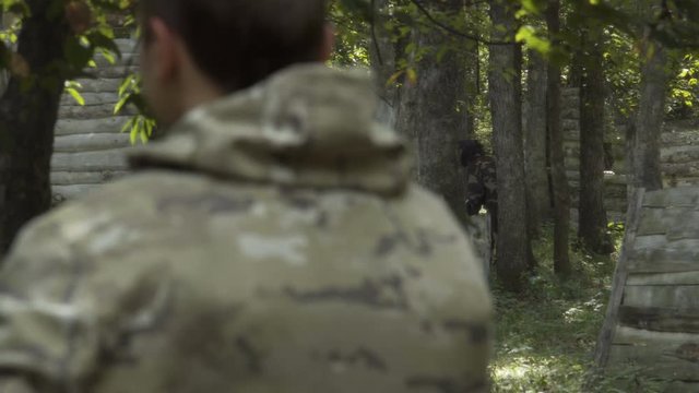People play paintball in the woods