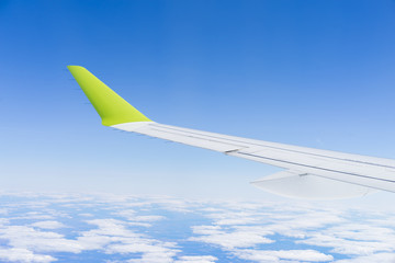 Fototapeta na wymiar aircraft during flight wing blue sky clouds sunny