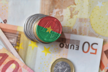 euro coin with national flag of burkina faso on the euro money banknotes background.