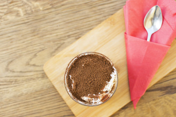 Chocolate mousse in a glass n a wooden background. Beautifully served dessert at the restaurant.