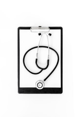 Doctor's table. Clip pad and stethoscope on white background top view