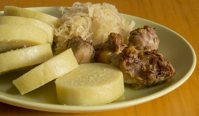 pork, dumplings and sauerkraut on green plate, tradition middle european food