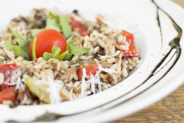 Fragrant Pilau/Pulav / pilaf /pilaf, fried rice with meat and vegetables on a white plate. Isolated on a wooden table.