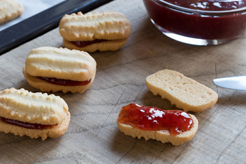 Filling Christmas cookies with strawberry jam
