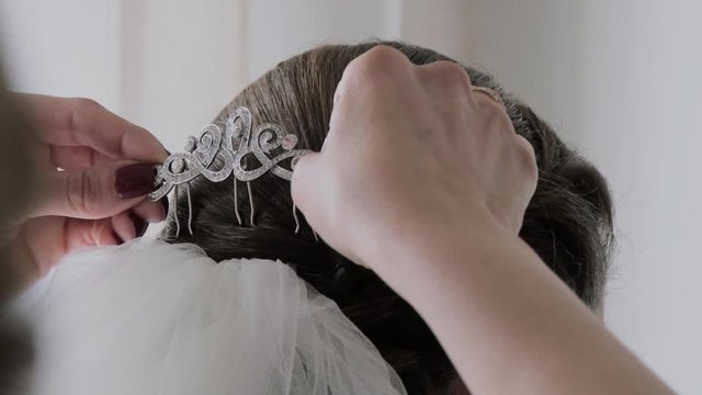 Hands of woman putting the comb of the veil of a wedding dress