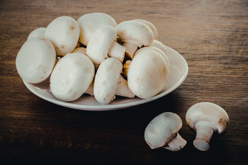 Fresh raw mashroom lying on a plate.