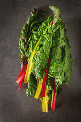 Rainbow chard, colorful eating and healthy diets. Dark background. A delicious diet.