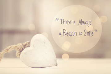 There Is Always A Reason To Smile message with a white heart  in a room