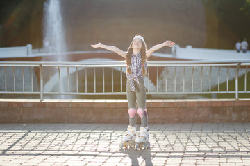 Fototapeta na wymiar Little girl rollerskating in park