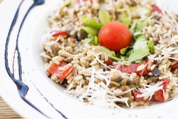 Fragrant Pilau/Pulav / pilaf /pilaf, fried rice with meat and vegetables on a white plate. Isolated on a wooden table.