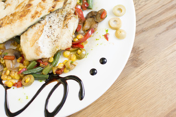 Grill chicken breast. Grilled vegetables with chicken breast. Grilled chicken with vegetables on oak table.