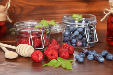 Fototapeta na wymiar blueberries and raspberries in jars for the winter tea