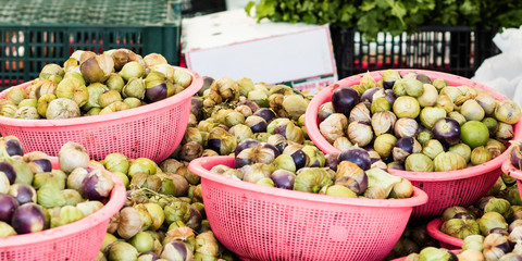 Figs at Farmers Market fruit stand. A colorful display of figs overflowing in pink baskets.  