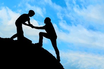 Silhouette of helping hand between two climber - Stock Image