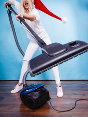 Angry girl in santa helper hat with vacuum cleaner