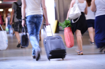 man walking with suitcase, blurred
