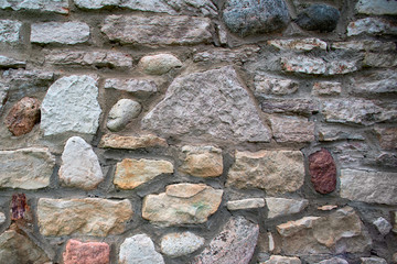 Texture of an ancient stone multicolored wall