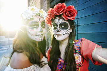 Women on sidewalk wearing skull face paint