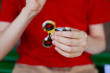 Boy playing with fidget spinner, close up. Childhood, gadgets, entertainment concept