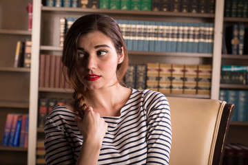 Young caucasian woman dressed like Jackie Kennedy poses in a library