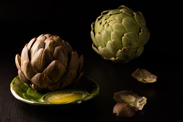 Obraz premium Artichoke for Dinner on plate with leaves on the table
