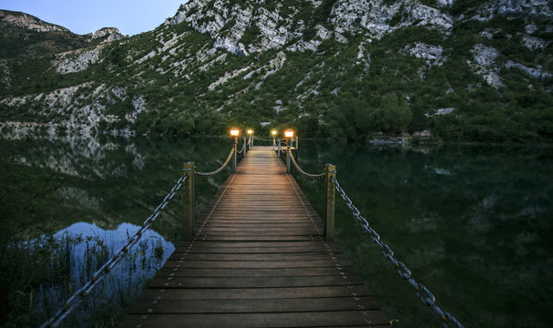 wooden bridge over a lake in the night