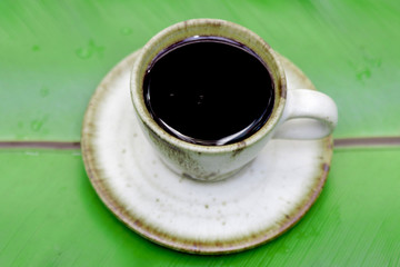  Enjoy morning coffee today with popular hot beverage menu,espresso coffee with golden fine-bubbled crema seen from above in crystal clear cup on bamboo plate in slow life day.