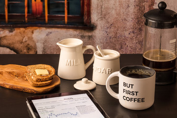But First Coffee with market report on tablet,  toast, milk, sugar horizontal