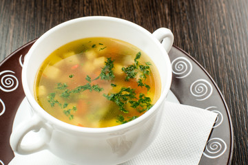 Beautiful presentation of the fish soup in a white plate on a wooden background.