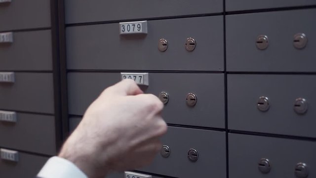 Unrecognisable bank manager with client old businessman hands closing up safe cell using two keys