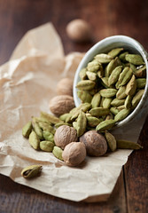 Dried Cardamon pods and nutmeg in a dish