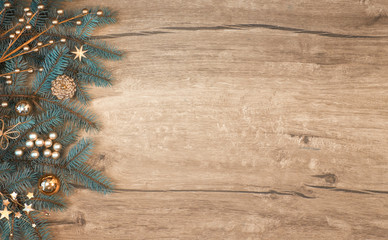 Christmas background with decorated fir tree branch border on wood.