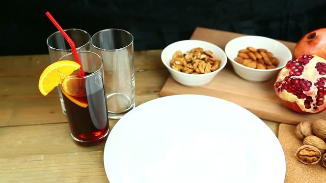 On a wooden table in plates are pomegranate, almonds, walnuts, oranges, rambutan. Hd shot with dolly .The camera moves from left to right