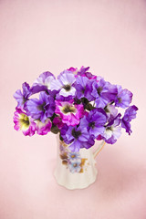 Beautiful Purple and Pink Silk Pansy Flowers on a Pink Background