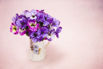 Beautiful Purple and Pink Silk Pansy Flowers on a Pink Background