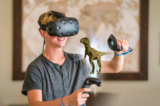 A teenage student wearing a virtual reality headset to study.
