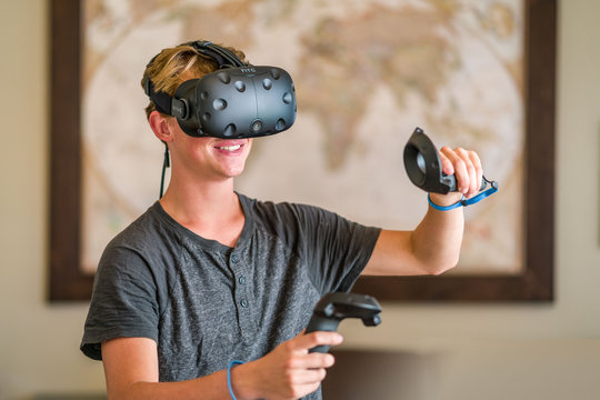 A teenage student wearing a virtual reality headset to study.