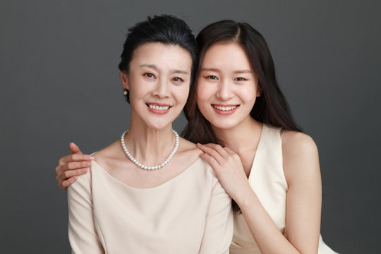 Studio portrait of woman with adult daughter