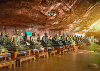 Many statues of Buddha under the cliffs