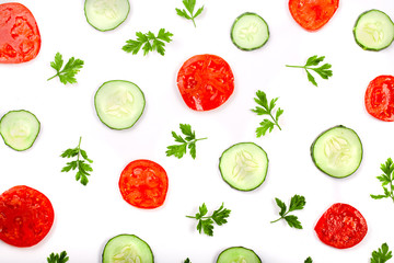 Cucumber and tomato slices with parsley leaves isolated on white background. Top view
