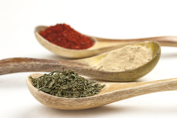 Close up of basil leaves in wooden spoon.