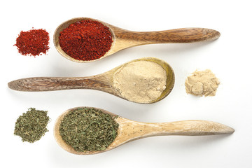 Cooking spices in spoons and piles.